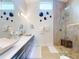 Elegant bathroom featuring dual sinks, stone countertops, and a luxurious walk-in shower with natural stone tile at 751 Pine Shores Cir, New Smyrna Beach, FL 32168