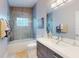 Modern bathroom with a large mirror, updated vanity, walk-in shower, and neutral color palette at 751 Pine Shores Cir, New Smyrna Beach, FL 32168