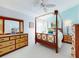 A well-lit bedroom showcases light-blue walls and a four-poster bed complemented by matching wooden furniture at 751 Pine Shores Cir, New Smyrna Beach, FL 32168
