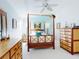 A bright bedroom features a four-poster bed and a matching wooden dresser at 751 Pine Shores Cir, New Smyrna Beach, FL 32168