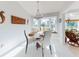 Bright dining room with views of the lake, featuring white chairs, a wooden table, and decorative wall art at 751 Pine Shores Cir, New Smyrna Beach, FL 32168