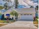 Charming single-story home featuring an attached garage, a well-manicured lawn, and mature trees at 751 Pine Shores Cir, New Smyrna Beach, FL 32168
