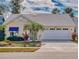 Charming yellow single-story home featuring a well-manicured lawn and an attached two-car garage at 751 Pine Shores Cir, New Smyrna Beach, FL 32168