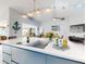 Kitchen island with ample counter space, modern lighting, and a view of the living and dining areas at 751 Pine Shores Cir, New Smyrna Beach, FL 32168