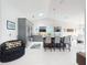 Open kitchen with stainless steel appliances, island with seating, and a view into the dining area at 751 Pine Shores Cir, New Smyrna Beach, FL 32168