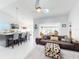 Open-concept living room featuring kitchen view, couch with decorative pillows and an overhead ceiling fan at 751 Pine Shores Cir, New Smyrna Beach, FL 32168