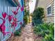 Charming stone walkway between two homes adorned with tropical plants and greenery at 751 Pine Shores Cir, New Smyrna Beach, FL 32168