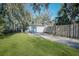 View of the detached two car garage featuring a long driveway and a lush lawn, providing ample parking and curb appeal at 820 Faulkner St, New Smyrna Beach, FL 32168