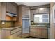 Open kitchen with vintage appliances, wood cabinets, stainless steel sink, and olive green counter at 820 Faulkner St, New Smyrna Beach, FL 32168