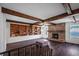Spacious living room featuring wood beams, hardwood floors, and a charming brick fireplace at 820 Faulkner St, New Smyrna Beach, FL 32168