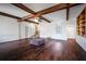 Spacious living room featuring wood beams, hardwood floors, and a charming built-in bookcase at 820 Faulkner St, New Smyrna Beach, FL 32168