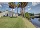 Scenic backyard featuring lush greenery, views of a serene waterway, and mature palm trees at 848 Pine Shores Cir, New Smyrna Beach, FL 32168