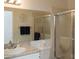 Bright bathroom featuring a shower, granite countertop, and decorative wall art at 848 Pine Shores Cir, New Smyrna Beach, FL 32168