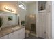Bright bathroom with a glass shower, arched window, and granite countertops at 848 Pine Shores Cir, New Smyrna Beach, FL 32168