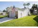 Exterior side view of home showing well-maintained lawn and charming architectural details at 848 Pine Shores Cir, New Smyrna Beach, FL 32168