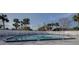 Wide view of a large swimming pool surrounded by palm trees and lounge chairs at 848 Pine Shores Cir, New Smyrna Beach, FL 32168