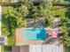 Aerial view of a backyard featuring a pool, brick patio, tropical plants, and lawn at 921 Duncan Rd, South Daytona, FL 32119