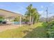 Backyard patio with a shady lanai, pool, lounge chairs, palms and green lawn at 921 Duncan Rd, South Daytona, FL 32119