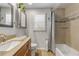 Bright bathroom featuring a tub with glass shelves, vanity with granite countertop, and a framed mirror at 921 Duncan Rd, South Daytona, FL 32119