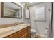 Bathroom featuring wood cabinets, granite countertops, and decorative mirror at 921 Duncan Rd, South Daytona, FL 32119