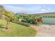 Exterior view of a green house with lawn and tropical plantings at 921 Duncan Rd, South Daytona, FL 32119