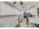 Galley kitchen with stone countertops, stainless steel appliances, tile backsplash, and bright lighting at 921 Duncan Rd, South Daytona, FL 32119