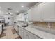 Bright galley kitchen featuring white cabinets, stone countertops, and stainless steel appliances at 921 Duncan Rd, South Daytona, FL 32119