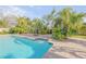 Inviting backyard pool with brick patio, steps and lush tropical landscaping at 921 Duncan Rd, South Daytona, FL 32119