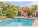 Beautiful pool with brick surround and lush tropical landscaping and lawn furniture at 921 Duncan Rd, South Daytona, FL 32119