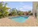 Inviting backyard pool area surrounded by lush landscaping and a brick-paved patio at 921 Duncan Rd, South Daytona, FL 32119