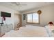 Bright bedroom with a ceiling fan, floral accents, and beach views from the windows at 921 N Atlantic Ave, New Smyrna Beach, FL 32169