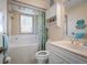 Cozy bathroom offers tub, white vanity, and neutral wall and shower tile at 923 Locust St, New Smyrna Beach, FL 32169