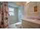 Well-lit bathroom with a tub/shower combo, decorative seashell shower curtain, and a vanity with a stone countertop at 923 Locust St, New Smyrna Beach, FL 32169
