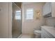 Bright bathroom features a glass shower and a large neutral tile flooring at 923 Locust St, New Smyrna Beach, FL 32169