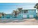 Inviting two-story blue home featuring a second-story balcony and an eye-catching rooftop deck at 923 Locust St, New Smyrna Beach, FL 32169