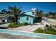 Stylish blue home with white trim, showcasing landscaping and the rooftop deck with an American flag at 923 Locust St, New Smyrna Beach, FL 32169