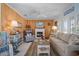 Well-lit living room with wood-paneled walls, a cozy fireplace, and beach-themed decor at 923 Locust St, New Smyrna Beach, FL 32169