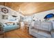 Comfortable living room showcasing a wet bar, daybed, sofa, wood plank ceiling, and nautical decorations at 923 Locust St, New Smyrna Beach, FL 32169