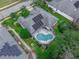 An aerial view of the home highlighting the yard, solar panels, screen enclosed pool, and the neighborhood at 936 Countryside West Blvd, Port Orange, FL 32127