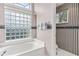 Bathroom featuring a tub with glass block window and a separate water closet at 936 Countryside West Blvd, Port Orange, FL 32127