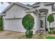 Close up of the front entrance showcasing the landscaping, a two-car garage, and an inviting front door at 936 Countryside West Blvd, Port Orange, FL 32127