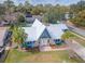 An aerial view of the house with a well-manicured lawn, palm trees, and unique architectural design at 950 Sand Crest Dr, Port Orange, FL 32127