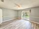 This bedroom features light gray walls, a ceiling fan, and sliding glass doors to the backyard at 950 Sand Crest Dr, Port Orange, FL 32127