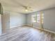 Bright bedroom featuring wood-look floors, a ceiling fan, and a window offering natural light at 950 Sand Crest Dr, Port Orange, FL 32127