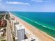 Aerial view of a high-rise condominium building with a pool overlooking the ocean and sandy beach at 1 Oceans West Blvd # 6A5, Daytona Beach, FL 32118