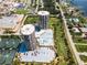 Aerial view of condos featuring a pool, tennis courts, parking, and convenient street access at 1 Oceans West Blvd # 6A5, Daytona Beach, FL 32118