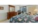 Comfortable bedroom with a dresser, TV and balcony that offers a peaceful retreat at 1 Oceans West Blvd # 6A5, Daytona Beach, FL 32118