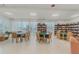 Community library space with tables, chairs, bookshelves, and natural light for reading and study at 1 Oceans West Blvd # 6A5, Daytona Beach, FL 32118