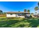 Lush backyard with green grass and mature trees providing shade, partially enclosed by a wood fence at 1039 Beulah Dr, Edgewater, FL 32132