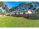 View of the front exterior highlighting the lawn, brick accents, and fenced yard at 1039 Beulah Dr, Edgewater, FL 32132